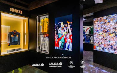 Soccer jerseys and World Cup celebration photo in museum exhibit.