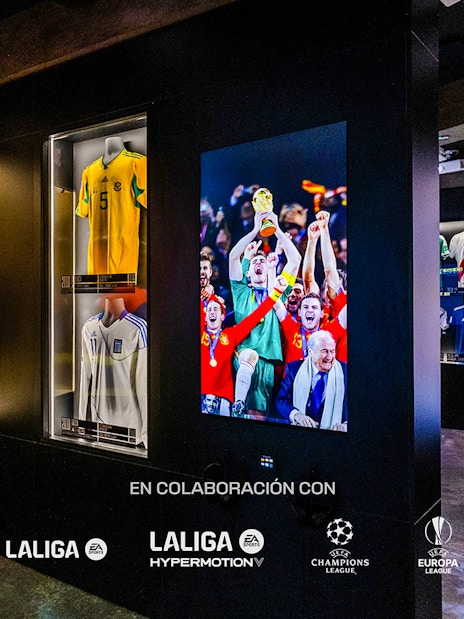 Soccer jerseys and World Cup celebration photo in museum exhibit.