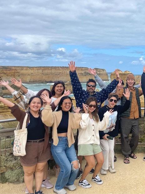 Group of tourists enjoying the view at Great Ocean Road during a full-day guided tour.