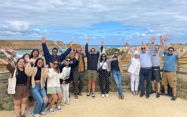 Group of tourists enjoying the view at Great Ocean Road during a full-day guided tour.