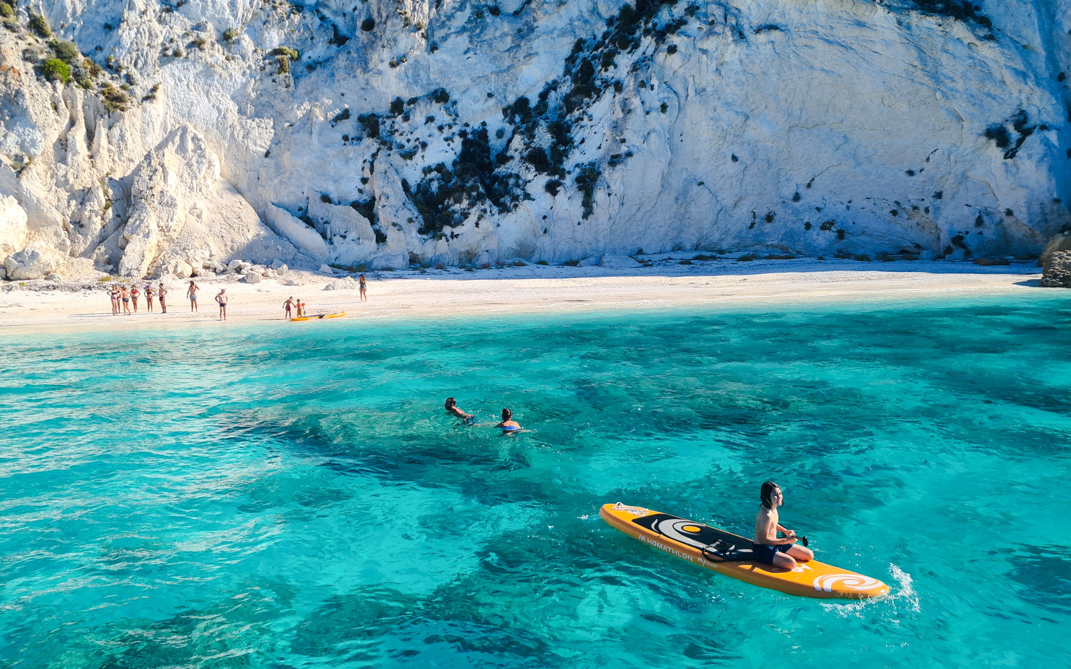 Paddleboarder on turquoise waters near Kefalonia beach cliffs, Dreamy Cruise.