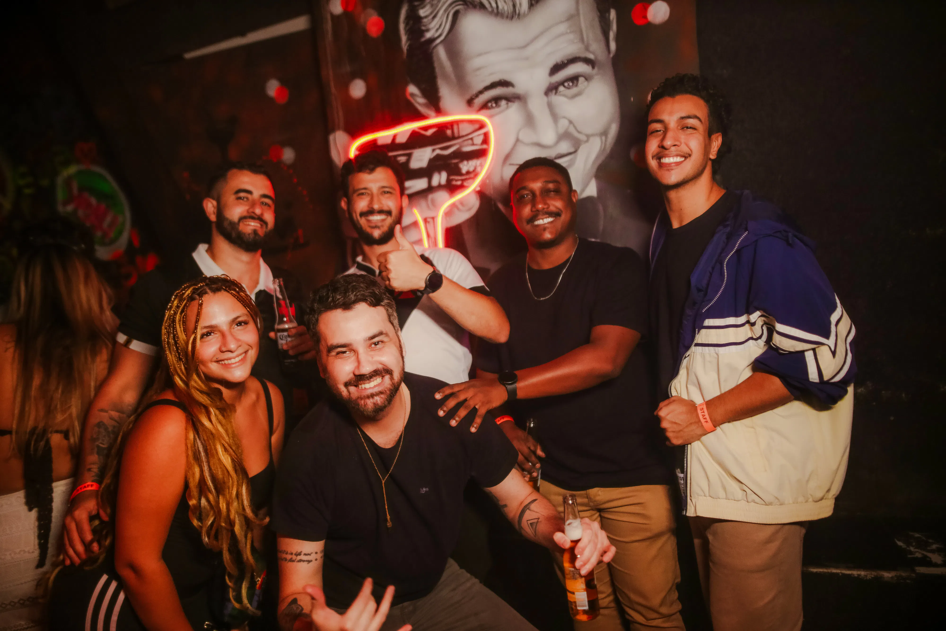 Group enjoying nightlife at Substation Club Rio, Rio de Janeiro, with neon art in the background.