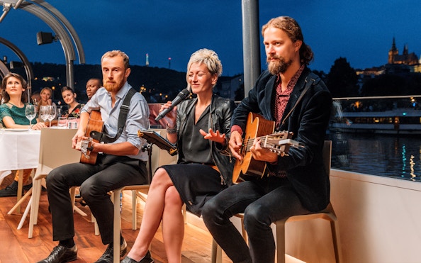 Live music performance on a Prague dinner cruise with cityscape views.
