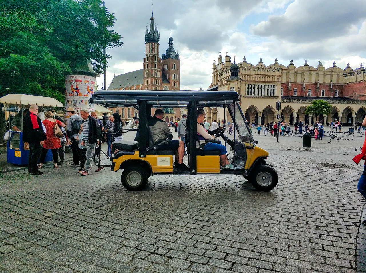 Golf cart tour in Krakow's Old Town near St. Mary's Basilica and Cloth Hall.
