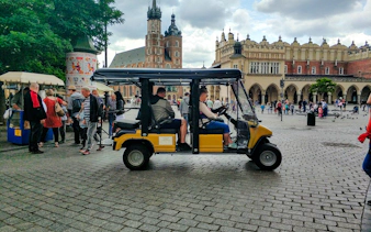 Golf cart tour in Krakow's Old Town near St. Mary's Basilica and Cloth Hall.