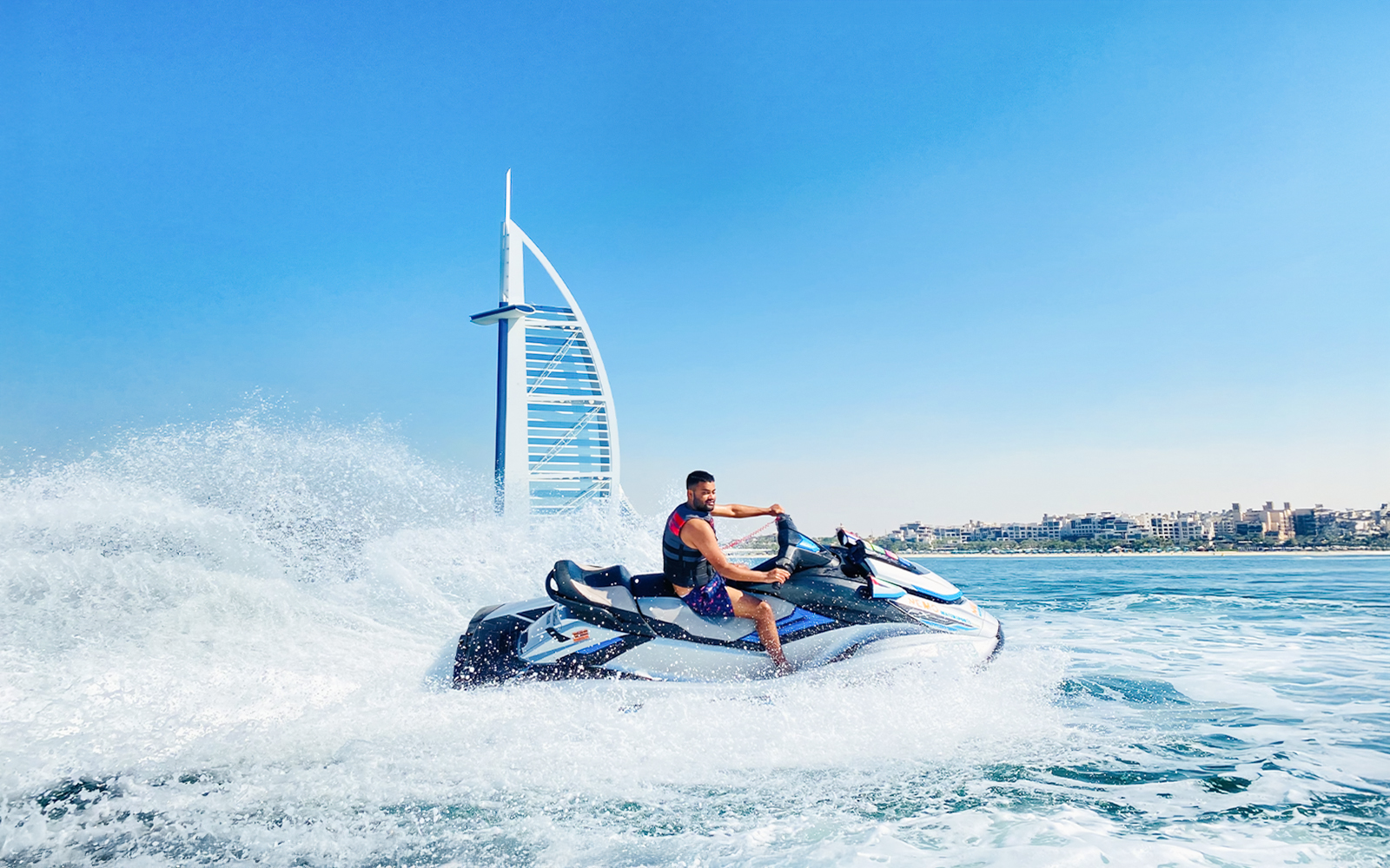 Tourist riding jet ski near Burj Al Arab in Dubai.
