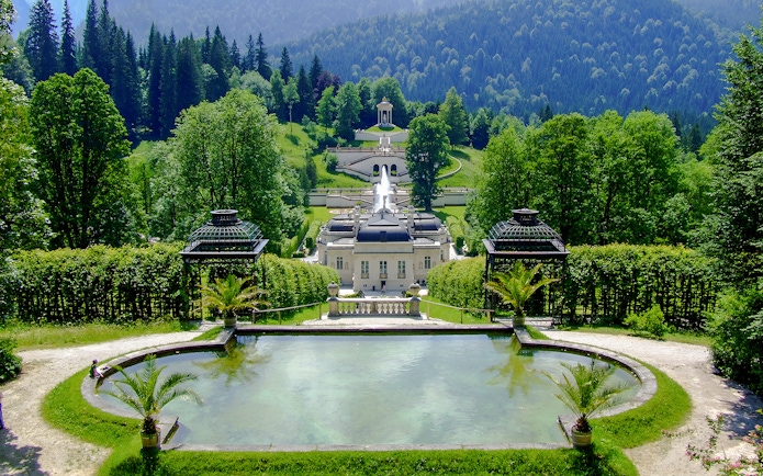 Linderhof Palace gardens with fountains and lush greenery in Bavaria, Germany.