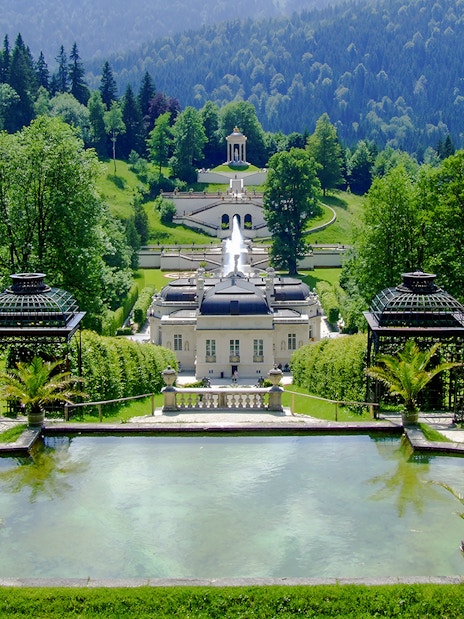 Linderhof Palace gardens with fountains and lush greenery in Bavaria, Germany.