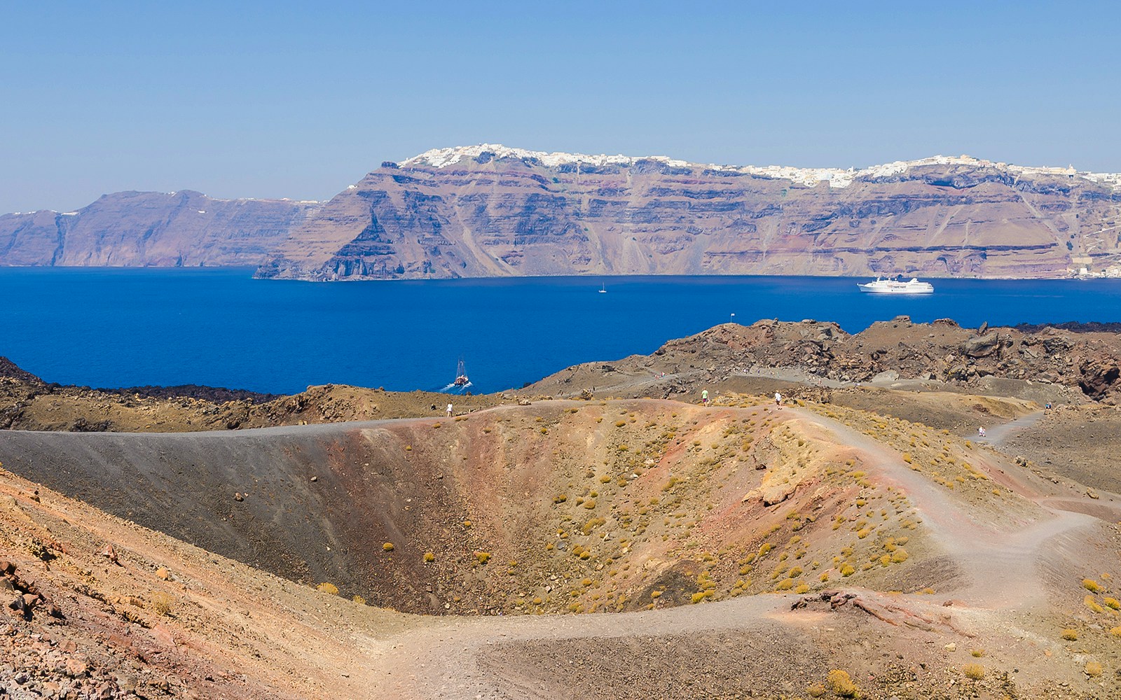 Santorini volcanic islands boat tour with view of caldera, hot springs, and Thirassia in Greece.