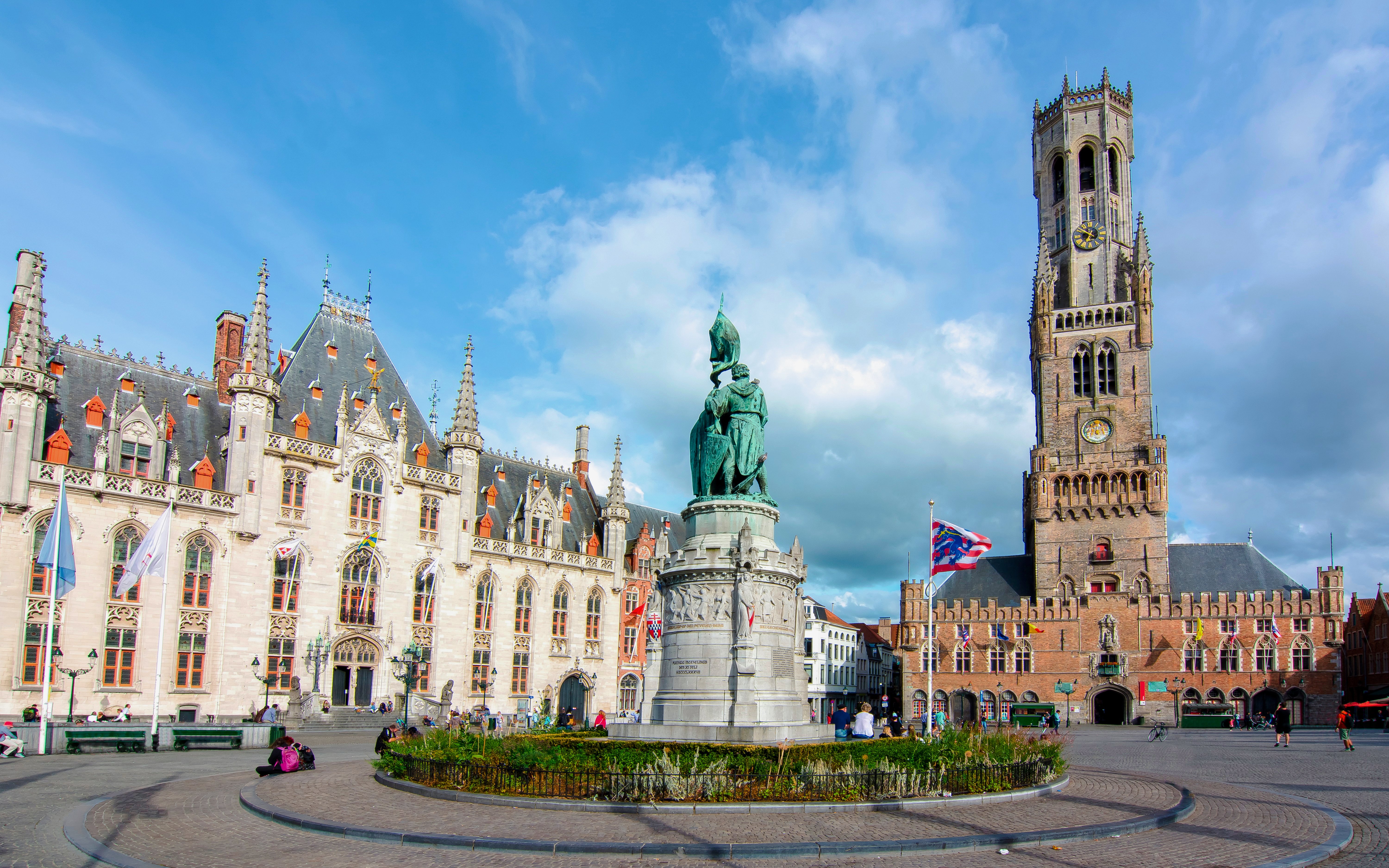 Markt Square in Bruges, Belgium with the Belfry tower and statue in the foreground.