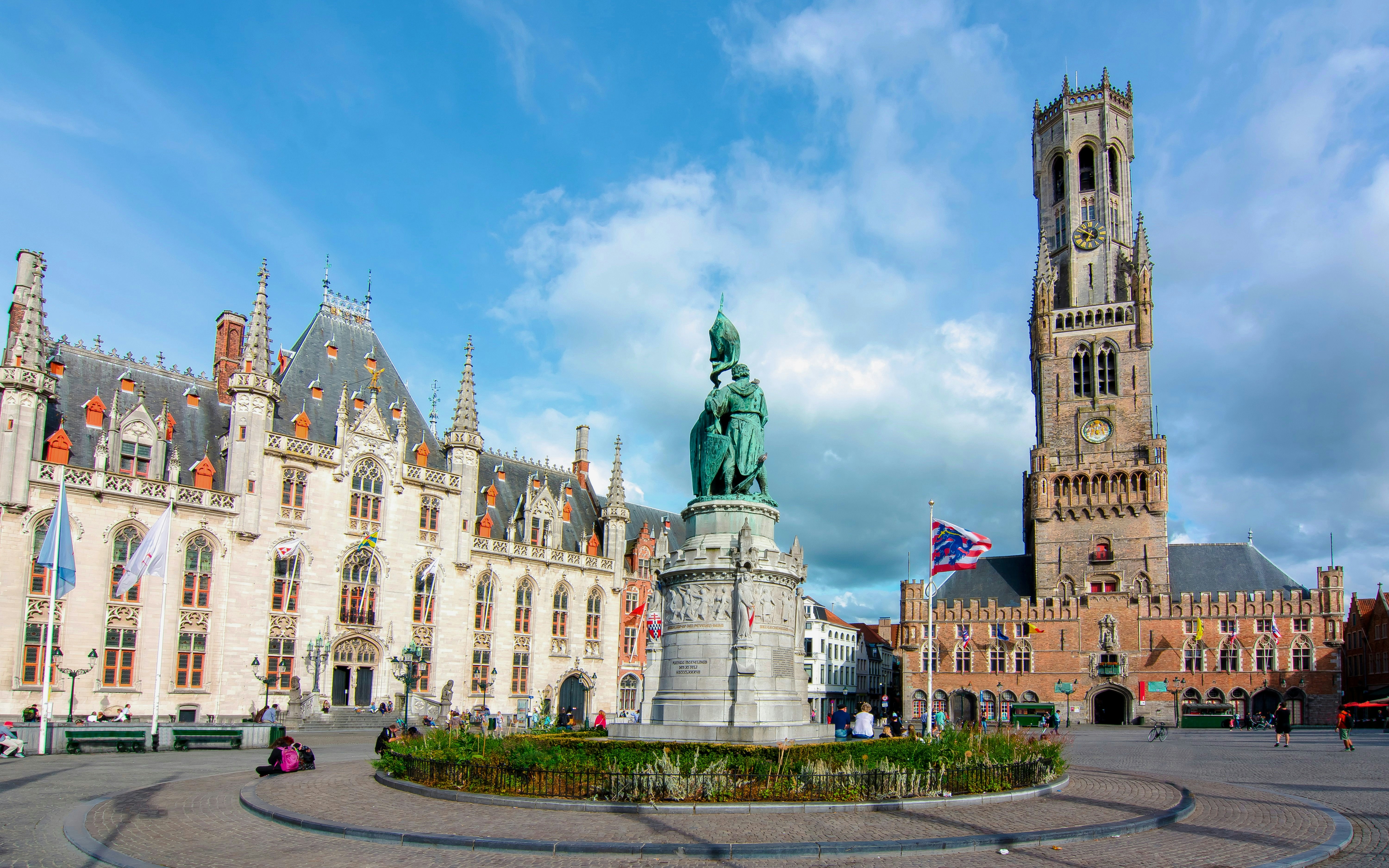 Markt Square in Bruges, Belgium with the Belfry tower and statue in the foreground.