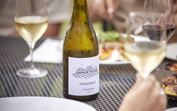 Bottle of Sirromet Chardonnay 2019 with wine glasses on a table during a winery tour and tasting.