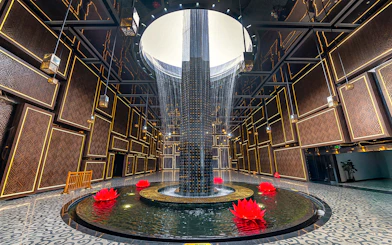 Water feature with red lotus flowers inside Ba Den Mountain tourist area, Tay Ninh, Vietnam.