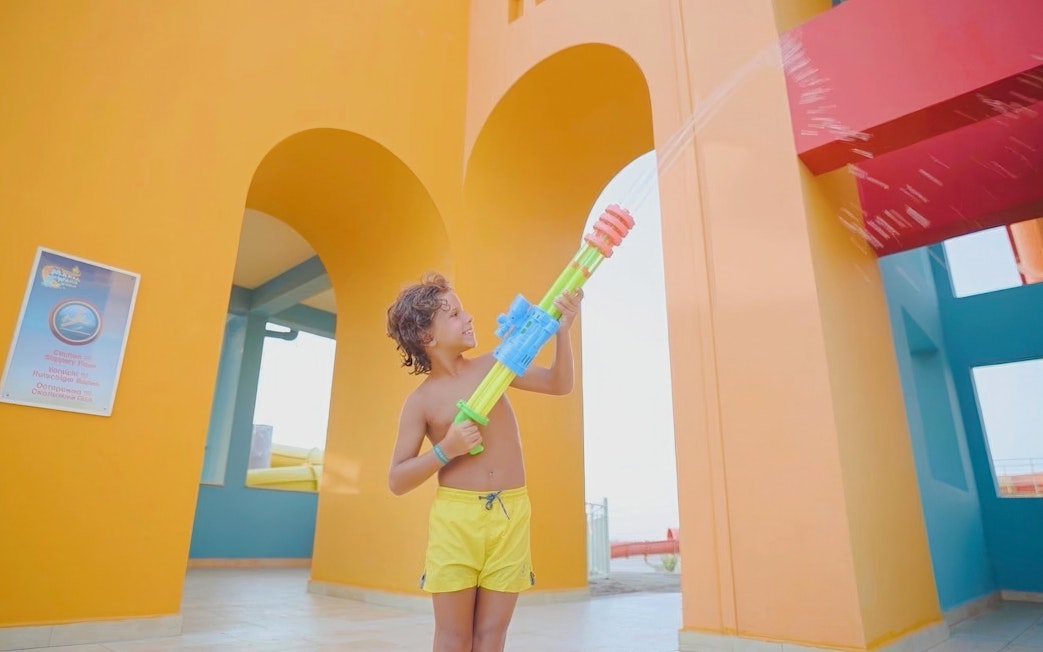 Child playing with water gun at Makadi Water World, Hurghada.