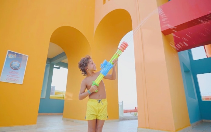 Child playing with water gun at Makadi Water World, Hurghada.