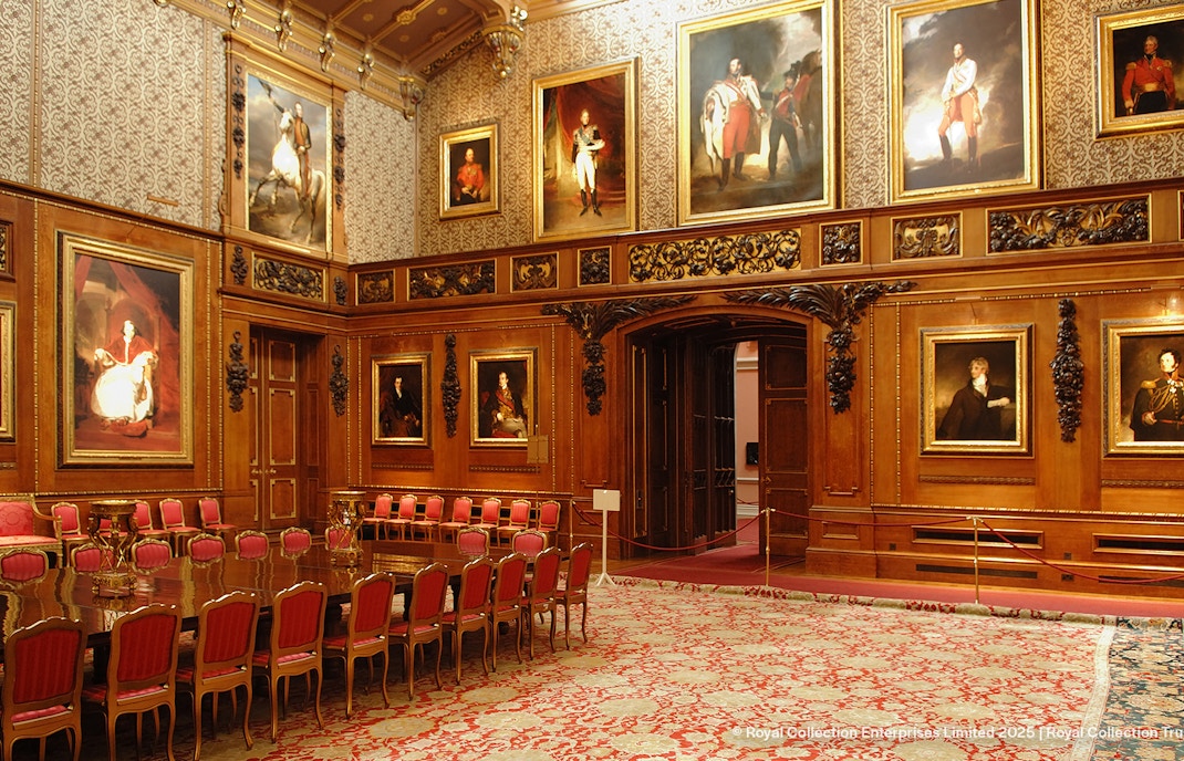 Windsor Castle interior with ornate wood paneling and historical portraits.