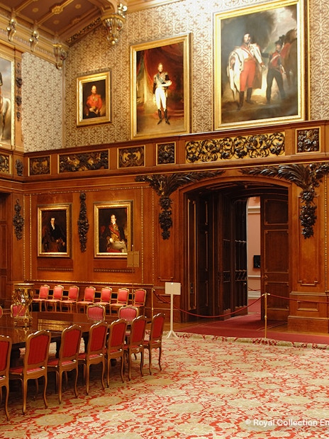 Windsor Castle interior with ornate wood paneling and historical portraits.