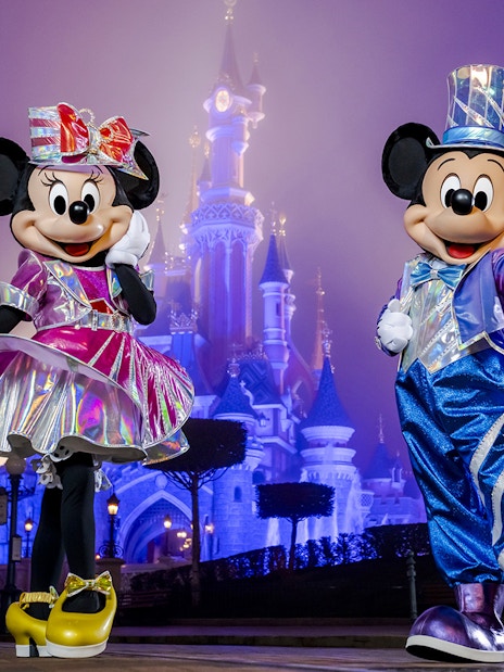 Mickey and Minnie Mouse in front of Sleeping Beauty Castle at Disneyland Paris.