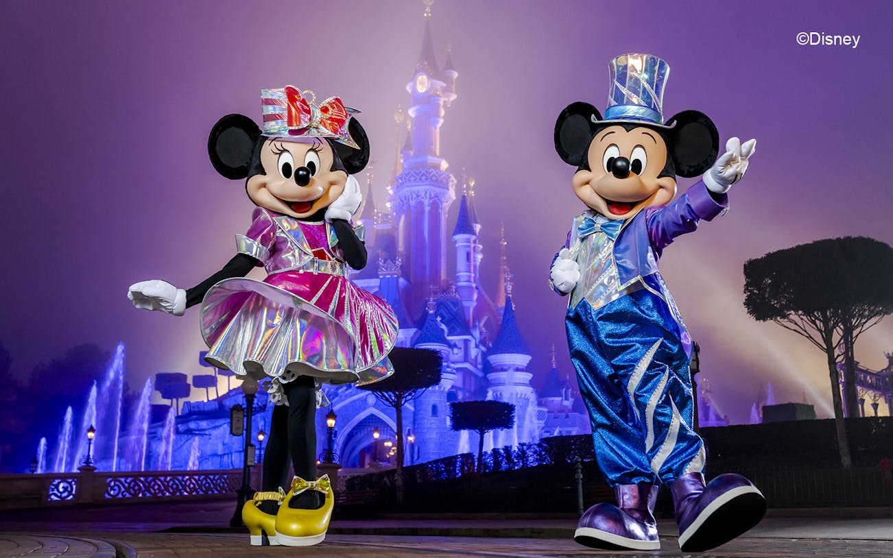 Mickey and Minnie Mouse in front of Sleeping Beauty Castle at Disneyland Paris.