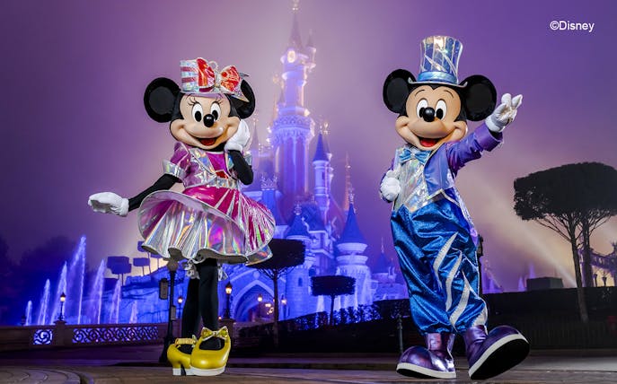 Mickey and Minnie Mouse in front of Sleeping Beauty Castle at Disneyland Paris.