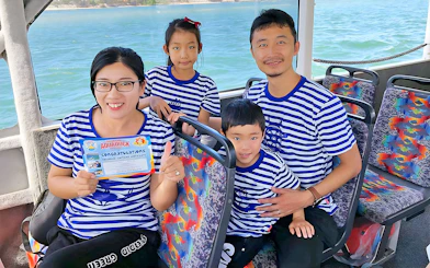 Family on Aquaduck Sunshine Coast tour holding certificate, seated on river cruise boat.