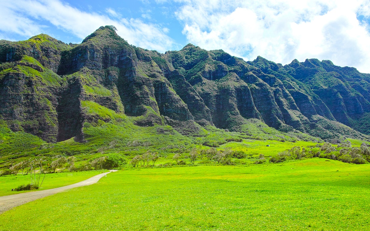 Kualoa Ranch lush green valley with towering mountains in Hawaii.