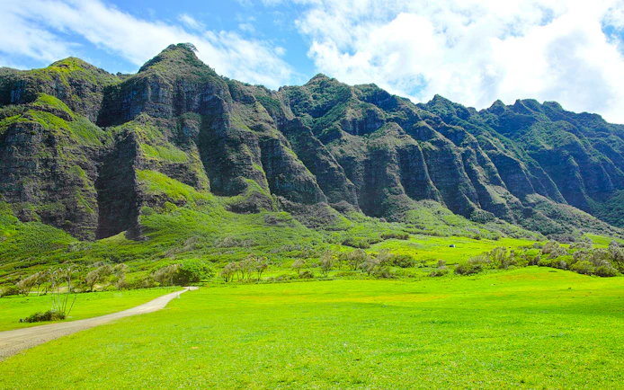 Kualoa Ranch lush green valley with towering mountains in Hawaii.
