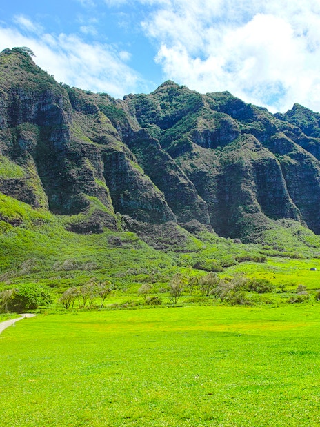 Kualoa Ranch lush green valley with towering mountains in Hawaii.