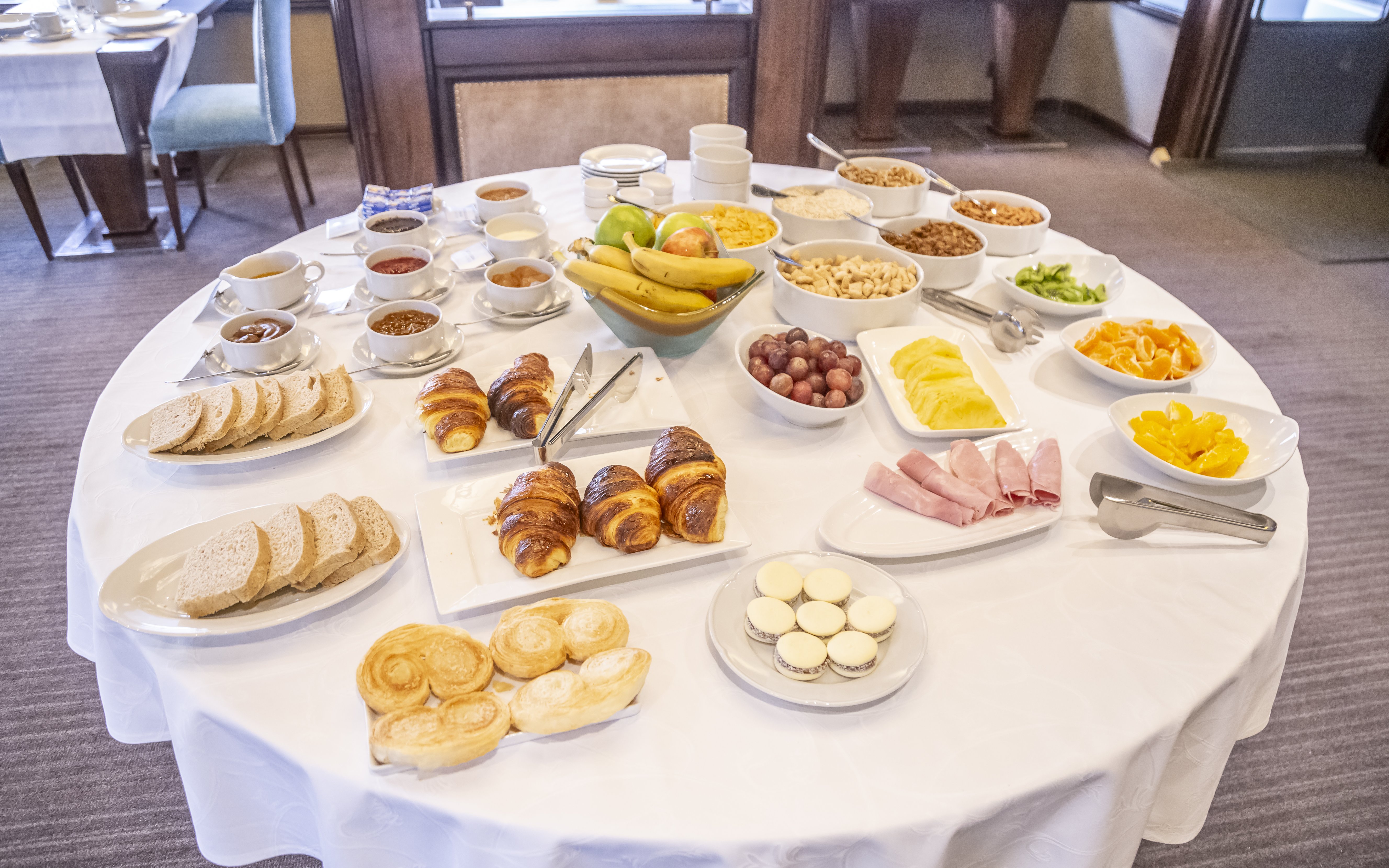 Food spread with pastries, fruits, and cold cuts on Spirit of the Glaciers tour.