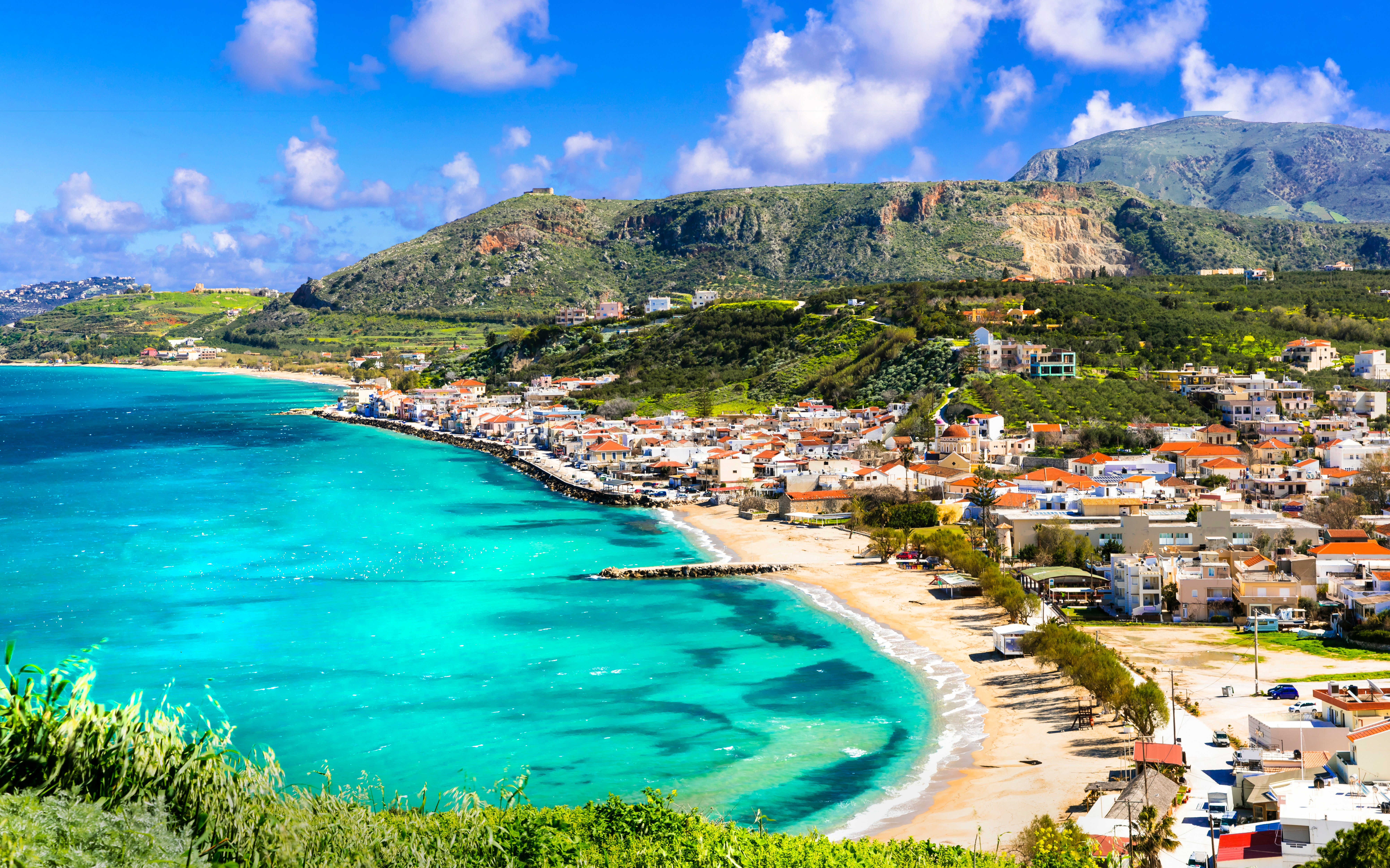 Coastal view of Almyrida Bay with turquoise waters and village on Crete island, Greece.