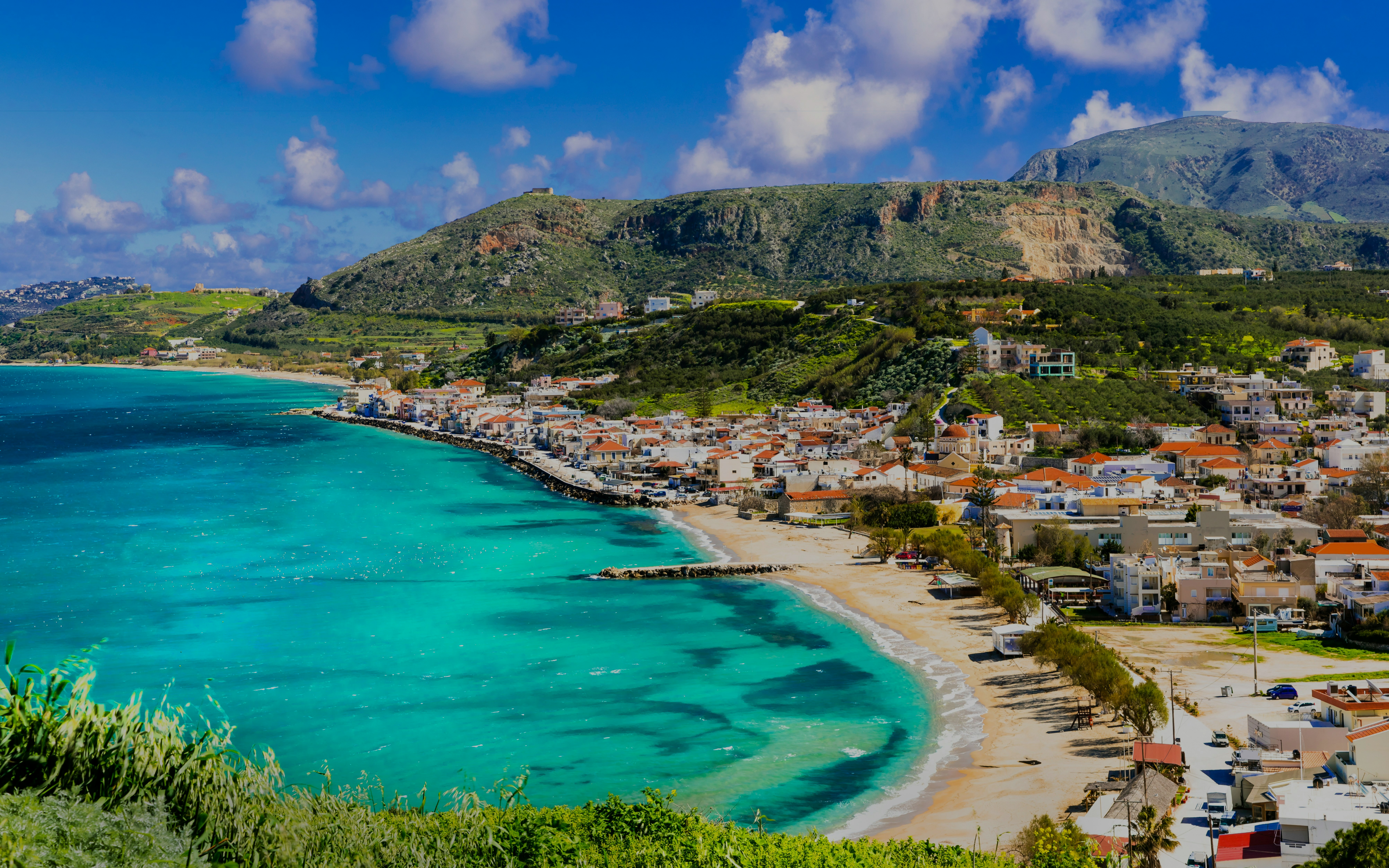 Coastal view of Almyrida Bay with turquoise waters and village on Crete island, Greece.
