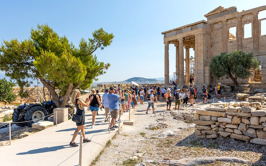 Visitors walking near the Parthenon in Athens, Greece.