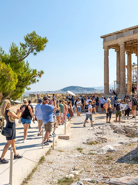 Visitors walking near the Parthenon in Athens, Greece.