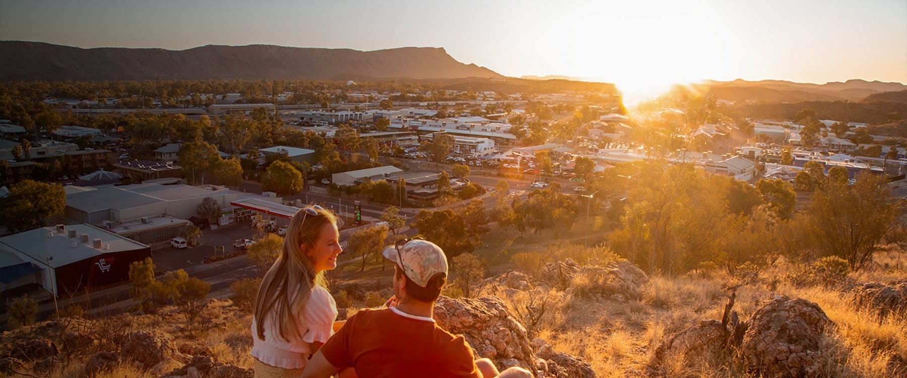 Couple enjoying sunset view over Alice Springs, Australia.