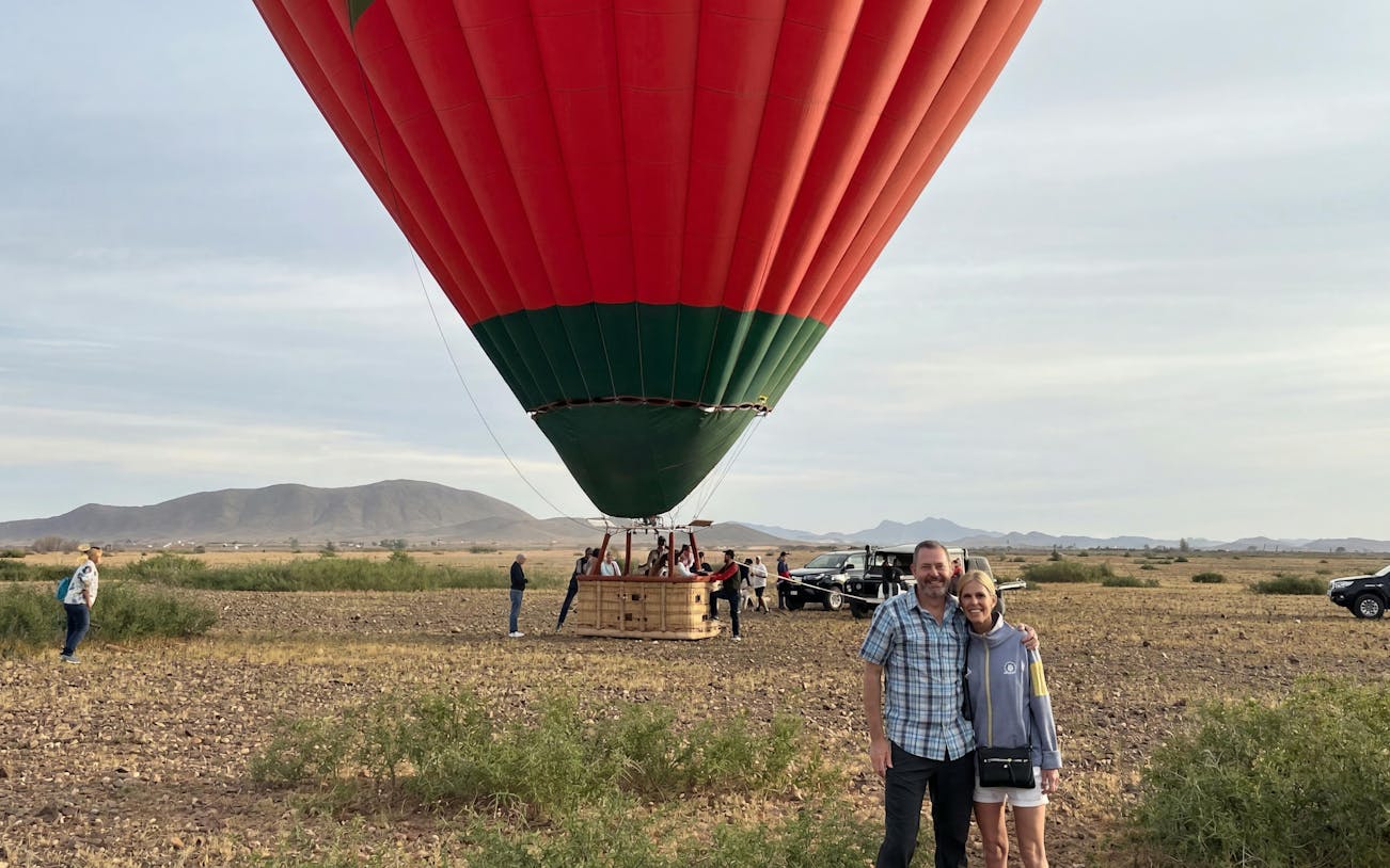 Hot air balloon preparing for sunrise flight in Marrakech desert landscape.