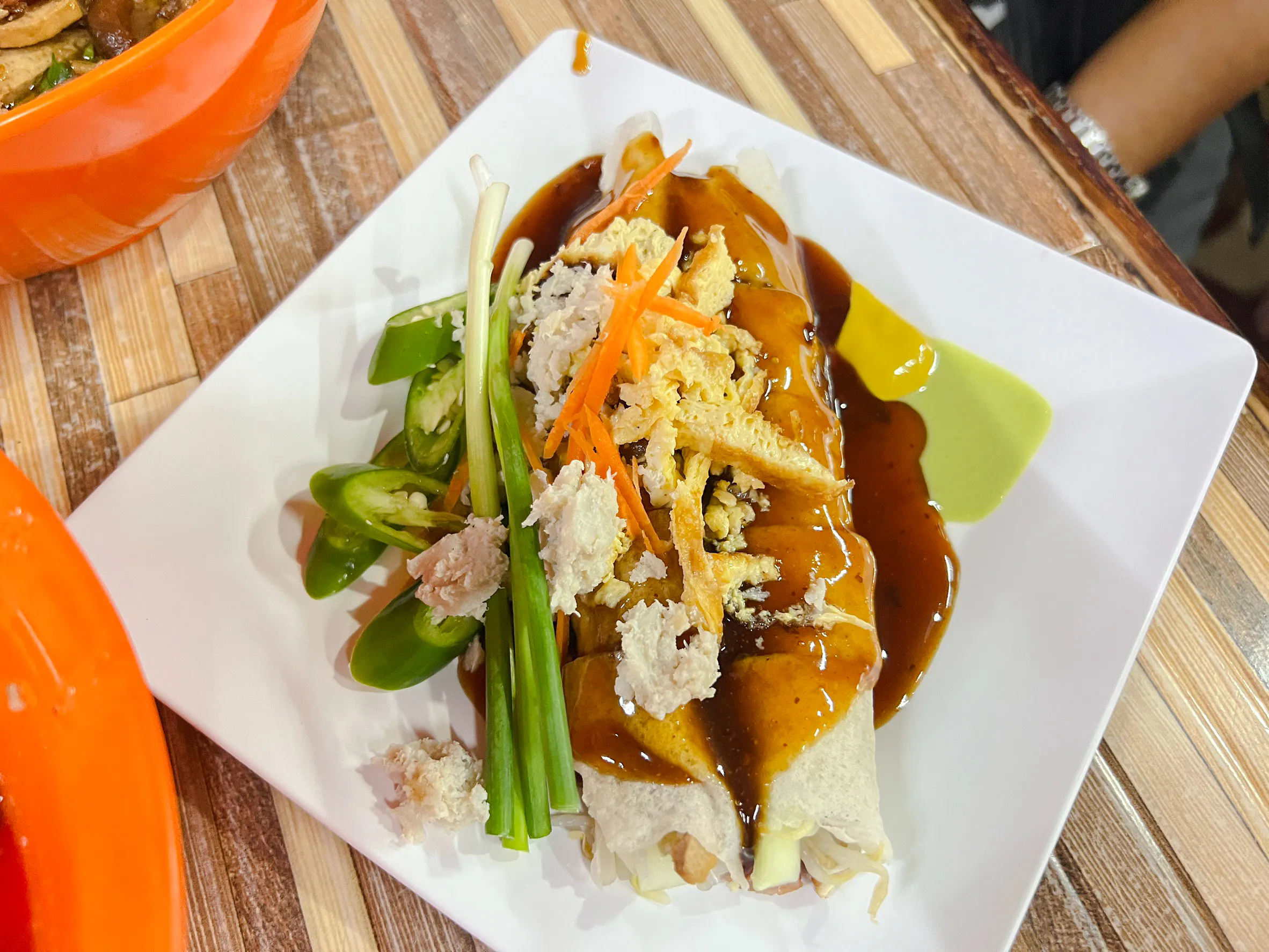Chiang Mai street food dish with sauce and fresh vegetables on a plate.