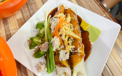 Chiang Mai street food dish with sauce and fresh vegetables on a plate.