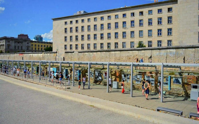 Visitors at the Topography of Terror outdoor exhibition in Berlin, viewing historical displays.