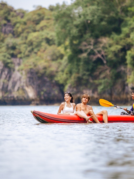 Canoeing with local paddler in scenic limestone landscape.