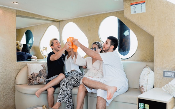 Group enjoying drinks on AC lower deck of a yacht.
