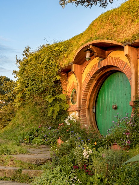 Hobbiton Movie Set with round green door and garden, Auckland tour.
