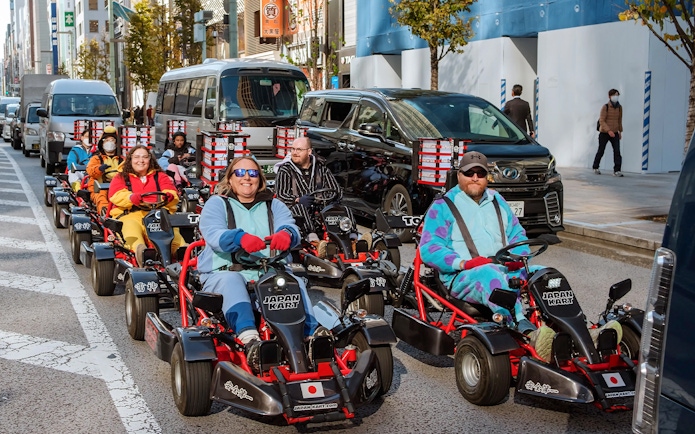 People driving go-karts on Asakusa streets during a 60-minute tour.