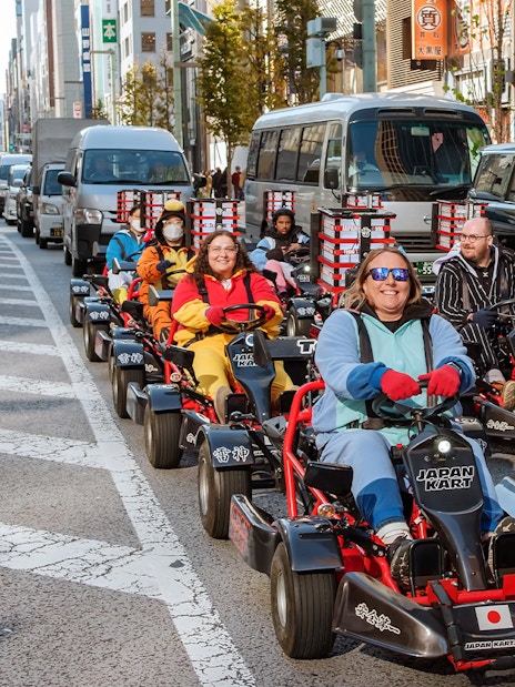 People driving go-karts on Asakusa streets during a 60-minute tour.