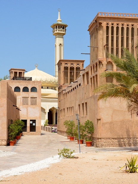 Al Fahidi Historical District with traditional wind towers and a mosque in Dubai.