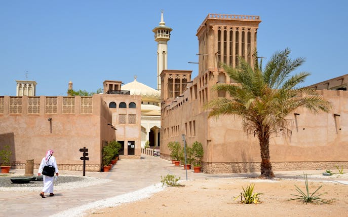 Al Fahidi Historical District with traditional wind towers and a mosque in Dubai.