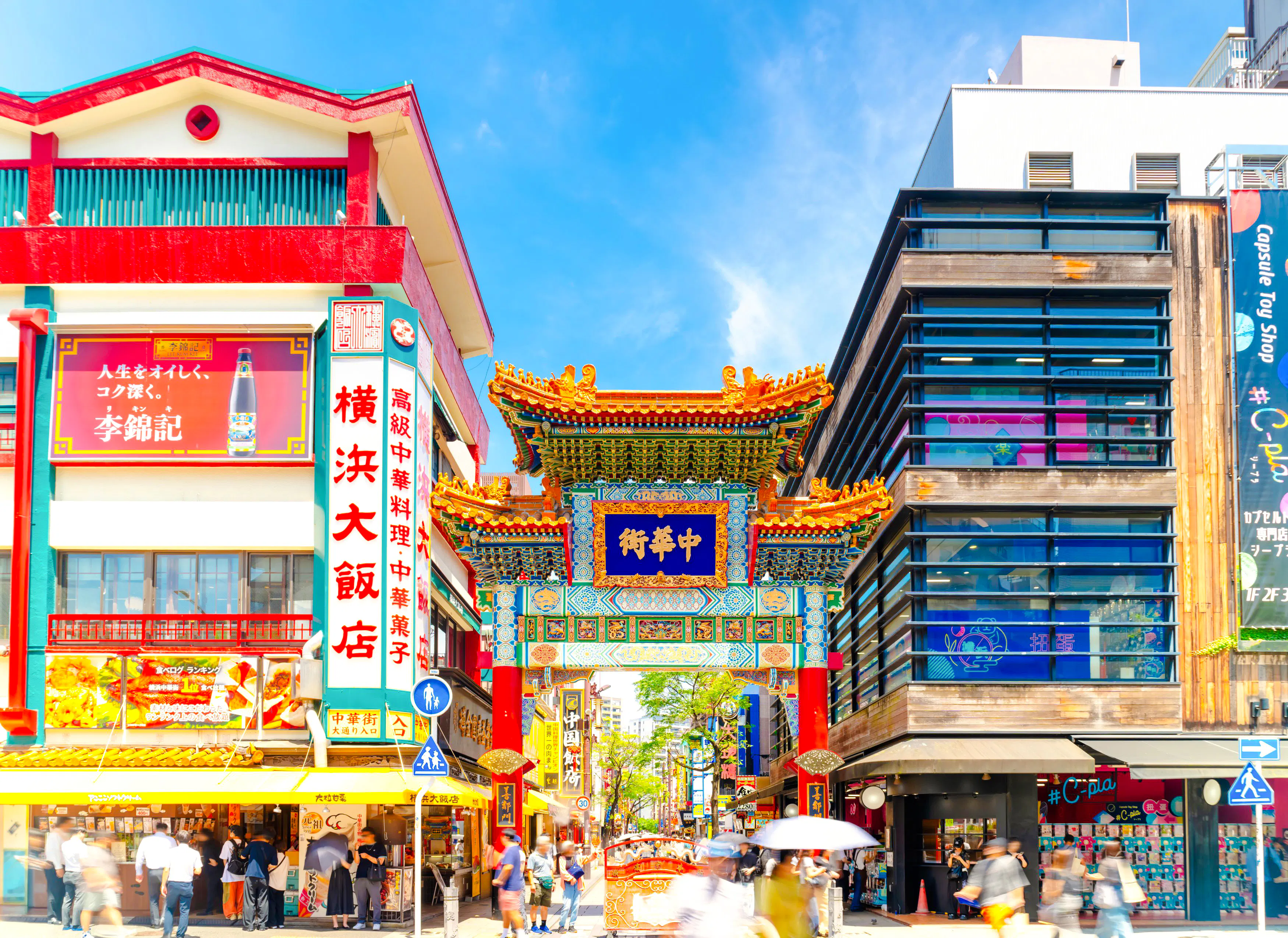 Yokohama Chinatown gate with colorful architecture and bustling street scene.
