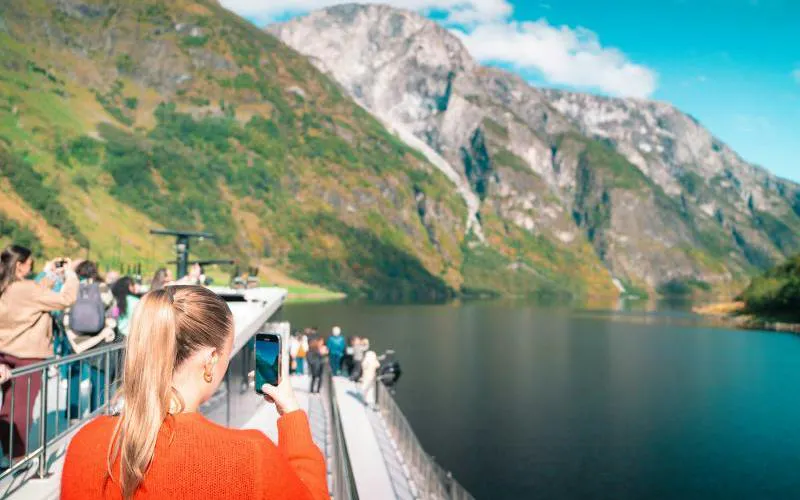 Tourists on a boat cruise through Nærøyfjord with mountains in the background, Bergen.