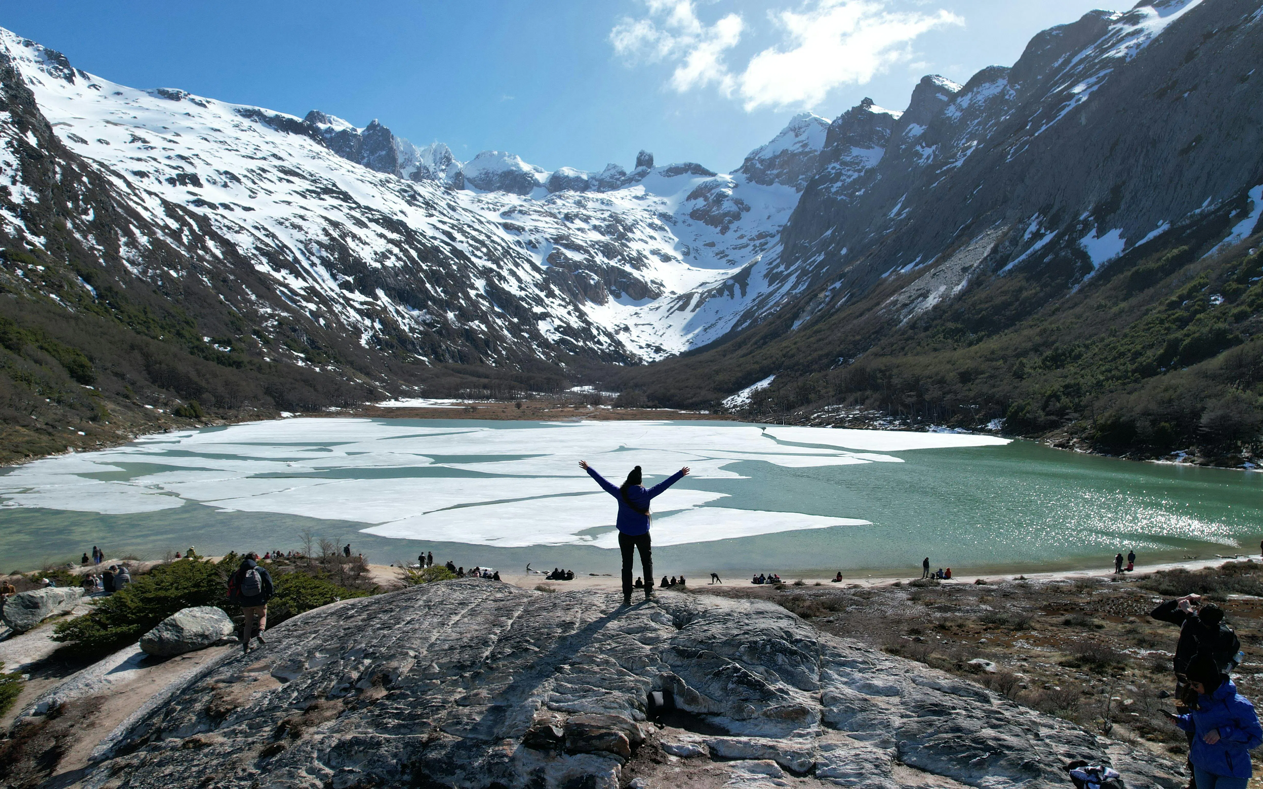 Trekker at Esmeralda Lake with snow-capped mountains in Tierra del Fuego, Argentina.