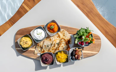Assorted dips and flatbreads on a wooden platter at Yona Beach Club, Phuket.