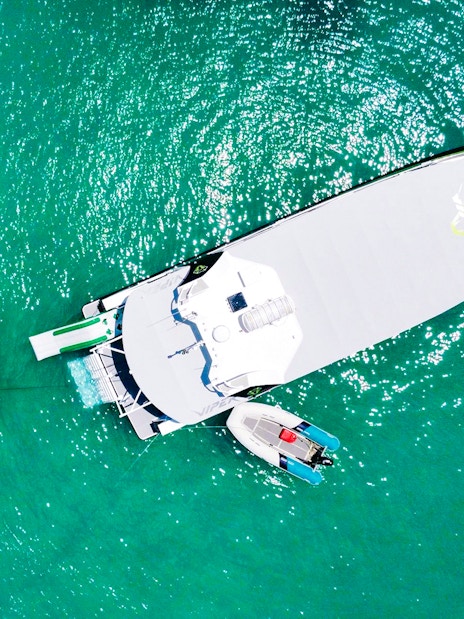 Aerial view of tourists on a boat and floating mat in Whitsundays.